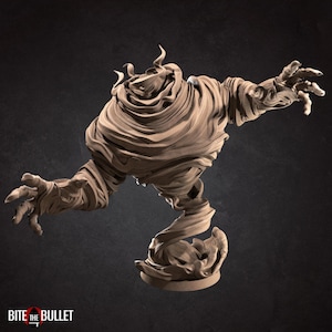 May include: A tan-colored, stylized sculpture of a spectral figure with outstretched arms. The figure appears to be made of swirling fabric or material, with detailed textures and a dynamic pose. The base is a circular platform.