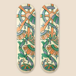May include: Two wooden skateboard decks with a colorful floral design. The design features orange, pink, green, and blue flowers with butterfly accents. The background is a light beige.