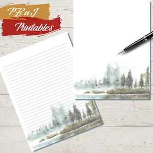 May include: Printable stationery featuring a watercolour illustration of a misty forest scene with trees and birds flying over a lake. The paper has lined writing space.