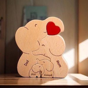 Peut inclure: Puzzle en bois en forme de famille d'&eacute;l&eacute;phants avec un c&oelig;ur rouge. Les &eacute;l&eacute;phants sont &eacute;tiquet&eacute;s "Papa", "Maman", "Ava" et "Kennedi".