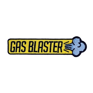 Könnte beinhalten: Gestickter Aufnäher mit dem Schriftzug "GAS BLASTER" in Marineblau auf einem gelben Rechteck. Auf der rechten Seite befindet sich ein blaues wolkenartiges Design mit gelben Linien. Der Aufnäher hat einen schwarzen Rand.