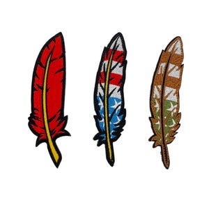 Puede incluir: Tres parches bordados para planchar con diferentes plumas de colores. El primer parche es rojo con un centro amarillo, el segundo es azul con rayas blancas y rojas, y el tercero es marrón con rayas verdes y blancas.