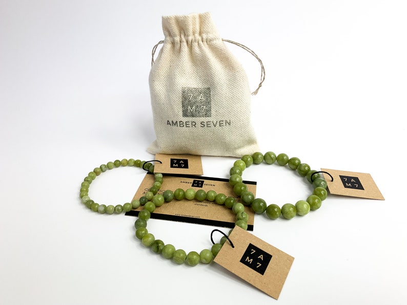 May include: Three green jade stone bracelets with brown paper tags that say "Amber Seven" and a small white drawstring bag with the same text.