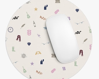 May include: A round beige mouse pad with a repeating pattern of various icons in different colors, including a guitar, a star, a diamond, a feather, a snake, a traffic light, a heart, a boot, a disco ball, a lighter, a typewriter, a bird, a bottle of wine, a scarf, a number "13", and a dice. A white computer mouse is on top of the mouse pad.