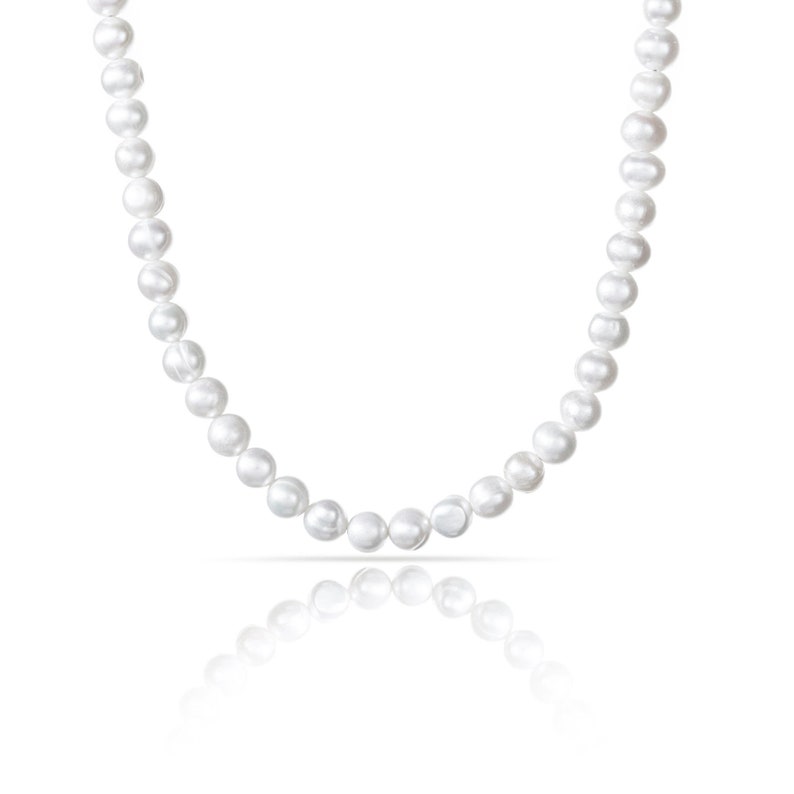 May include: A white pearl necklace with a classic design. The necklace is made of round pearls and is strung on a thin chain.