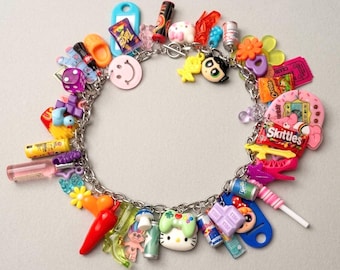 May include: A silver-toned metal charm bracelet featuring a variety of colorful miniature plastic charms including food items like Skittles and Cheetos bags, beverage cans, a game controller, cartoon characters, a dice, and various other small objects.