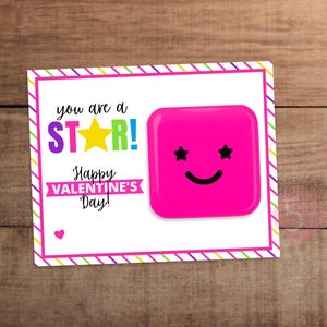 May include: Valentine's Day card with a pink square character with star eyes and a smile. The card reads "you are a STAR!" in purple, yellow, and green, with "Happy VALENTINE'S Day!" below.