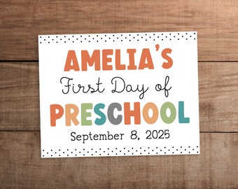 May include: A white card with black polka dots around the edges. The text "Amelia's First Day of PRESCHOOL" is in colorful letters. The date "September 8, 2025" is printed below the text.