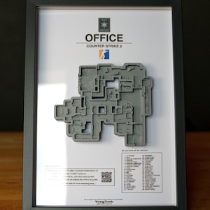 Pode incluir: Modelo 3D cinza emoldurado do mapa "Office" do Counter-Strike 2. O mapa &eacute; um relevo detalhado e texturizado, montado em um fundo branco dentro de uma moldura preta. A moldura inclui o logotipo do jogo e os nomes das &aacute;reas do mapa.