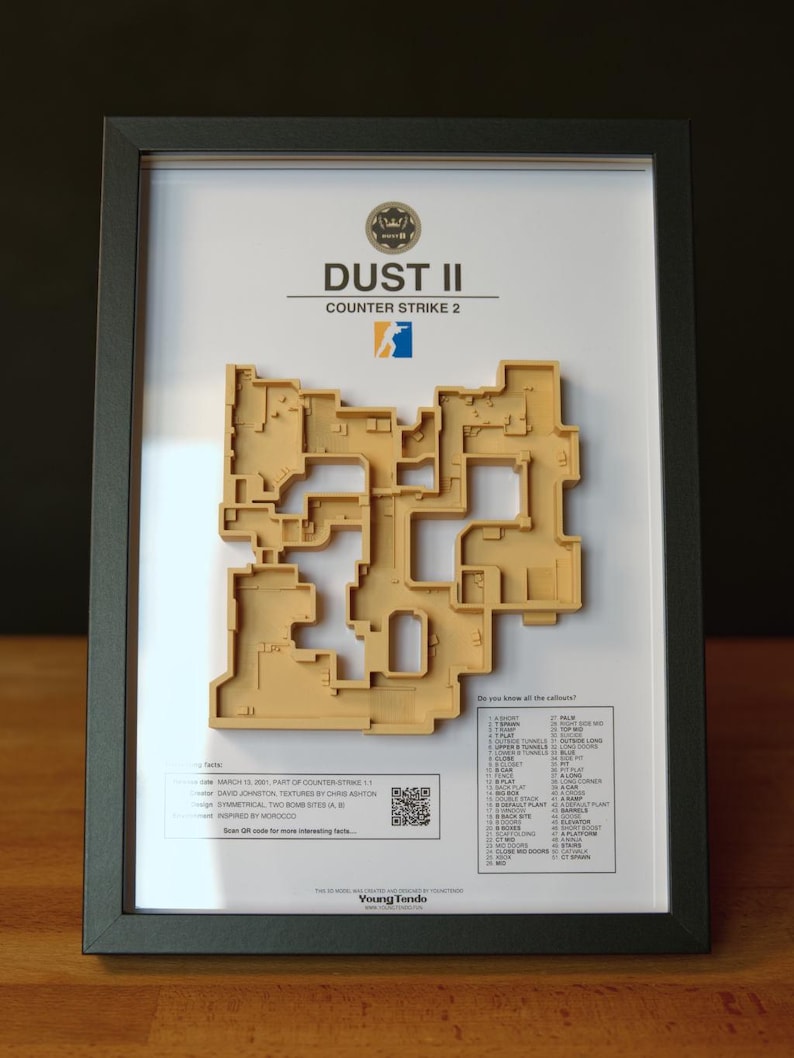 Pode incluir: Obra de arte emoldurada com um mapa 3D bege do n&iacute;vel Dust II do Counter-Strike 2. A obra de arte inclui o logotipo do jogo, texto e uma lista de chamadas. A moldura &eacute; preta e o fundo &eacute; branco.