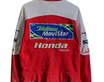 May include: Red, white, and blue racing jacket with "Telefonica Movistar" and "Honda MotoGP" logos.