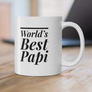 Könnte beinhalten: Weiße Keramiktasse mit schwarzem Text, der "World's Best Papi" lautet.