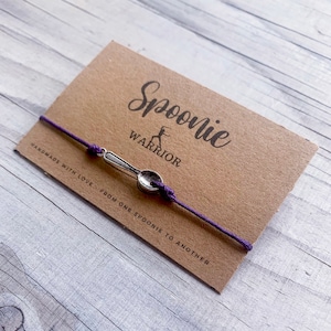 May include: Purple string bracelet with a silver spoon charm. The card reads "Spoonie Warrior" and "Handmade with love from one spoonie to another."