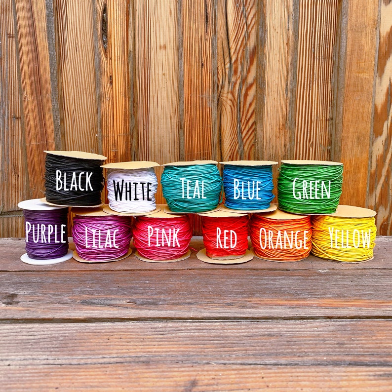 Puede incluir: Carretes de hilo de colores en varios colores, incluyendo negro, blanco, azul verdoso, azul, verde, morado, lila, rosa, rojo, naranja y amarillo. Los carretes est&aacute;n etiquetados con sus colores correspondientes.