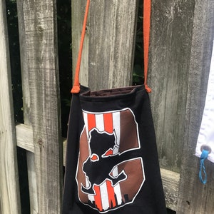 Muestras de diseñador transformadas en cartera tipo camiseta reciclada Brownie The Elf con correa cruzada naranja