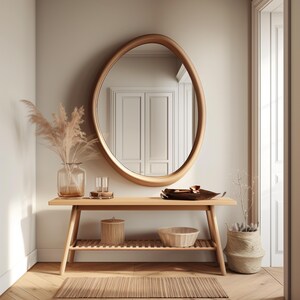 May include: A wooden console table with a shelf, a round mirror, a vase with dried pampas grass, a bowl, and a woven basket. The table is in a hallway with light wood floors.