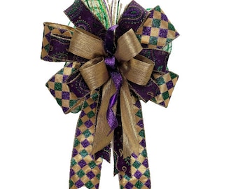 May include: A large, decorative bow with gold and purple ribbon. The bow has a checkered pattern and is tied with a gold ribbon.
