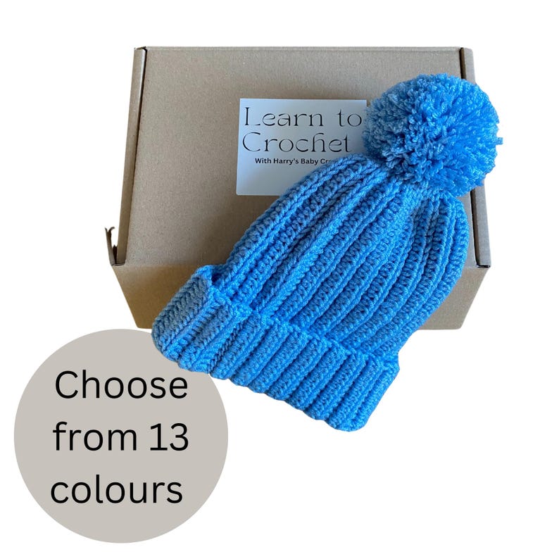A complete crochet kit, including yarn, hook, scissors, tape measure, pompom maker and PDF print out of the pattern for a hat with pompom.