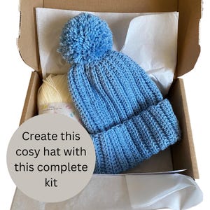 A complete crochet kit, including yarn, hook, scissors, tape measure, pompom maker and PDF print out of the pattern for a hat with pompom.