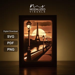 May include: A rectangular layered paper art light box featuring a silhouette of the Eiffel Tower in Paris at sunset, with street lamps along a riverbank. The text reads MODALIZED VISUALS, Digital Download, SVG, PDF, and PNG.