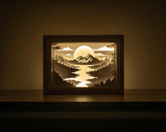 Plantilla de caja de luz con diseño de montañas 3D cortadas en formato SVG, plantilla de caja de luz con diseño de paisaje fluvial, plantilla de caja de sombra con diseño de bosque.