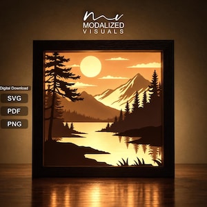 May include: A square framed layered paper art piece featuring a backlit mountain landscape with a lake, pine trees, and a sun. The text reads MODALIZED VISUALS, Digital Download, SVG, PDF, and PNG. The scene is illuminated in warm orange tones.