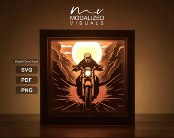 May include: A square shadow box light featuring a layered paper-cut design of a motorcyclist riding towards a large sun. The scene includes dark clouds and radiating light lines. Text on the left reads Digital Download, SVG, PDF, PNG.
