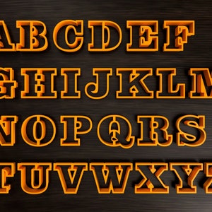 May include: An assortment of orange plastic letter-shaped cookie cutters, each approximately 3 inches tall, arranged on a dark wood-grain surface. The letters A through Z are displayed. The upper right corner features the text "3" CUTTERS DIGITAL IMAGE".