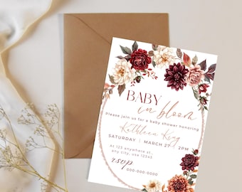 May include: Baby shower invitation with floral accents. The invitation features the text "Baby in Bloom" and details for the event, including the honoree's name, date, time, and location. A brown envelope is visible in the background.