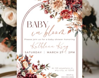 May include: Baby shower invitation with floral design. The invitation features the text "BABY in bloom" and details for Kathleen King's baby shower. The design includes burgundy, cream, and peach-colored flowers and foliage, with a brown border.