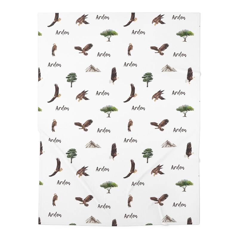 May include: White background with a repeating pattern of brown eagles, green trees, and brown mountains. The word "Arden" is repeated throughout the pattern.