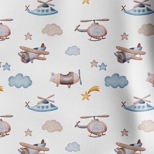 May include: A repeating pattern of watercolor illustrations featuring airplanes, helicopters, clouds, stars, and a shooting star. The color palette includes shades of blue, brown, and yellow on a white background. The design is suitable for children's products.