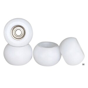 May include: Four white fingerboard wheels with silver bearings. The wheels are arranged in a row, with the front wheel slightly offset from the others.