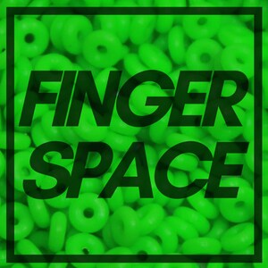 May include: A close-up image of a large quantity of bright green rubber rings. The text "FINGER SPACE" is superimposed on the image in black.