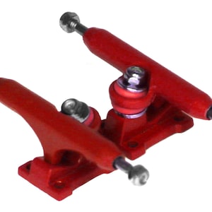 May include: A pair of red fingerboard trucks with silver hardware. The trucks are designed for fingerboards and are made of metal.