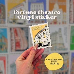 Puede incluir: Una pegatina de vinilo de un edificio de teatro vintage con el texto "Fortune Theatre" en ella. La pegatina se sostiene en una mano contra un fondo de muchas otras pegatinas de edificios de teatro vintage.