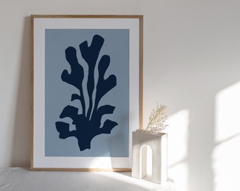 Puede incluir: Una impresión enmarcada de un diseño floral abstracto azul sobre un fondo azul claro. La impresión está en un marco de madera y está sobre una superficie blanca.
