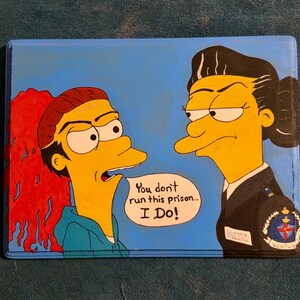 May include: Hand-painted artwork featuring two cartoon characters with yellow skin and black hair. One character is in a blue top and the other is in a black uniform. Text reads "You don't run this prison... I Do!"