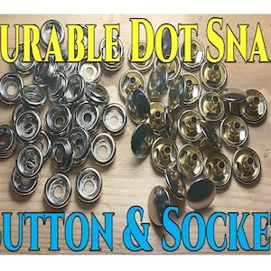 May include: A collection of silver and brass-colored Durable Dot Snap Button & Socket fasteners. The image shows a variety of snap button components, including the socket and button parts, arranged on a light brown wooden surface. The text "Durable Dot Snap" and "Button & Socket" are displayed.