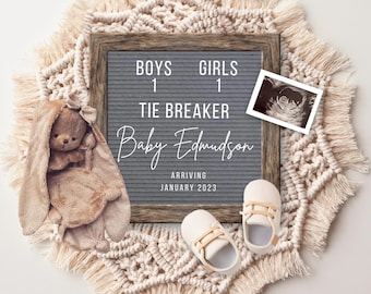 May include: A grey letter board with the text "Boys 1 Girls 1 Tie Breaker Baby Edmundson Arriving January 2023". A brown stuffed bunny, a pair of white baby shoes, and a black and white ultrasound image are on a beige crocheted rug.