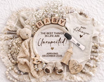 May include: A pregnancy announcement with a cream-colored onesie, a positive pregnancy test, and a sign that reads "The best things in life are unexpected!" with the baby's name and due date. The announcement includes baby shoes, a teddy bear, and wooden blocks spelling "BABY".
