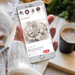 May include: A smartphone displaying an Instagram post featuring a wooden sign with the text "God gave us a perfect gift" and two baby onesies with the text "God gave us a perfect gift" and "Always my baby". The post has 2 likes and 1 comment.