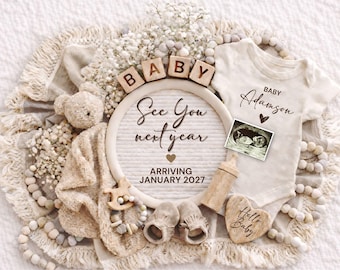 May include: A neutral-toned baby announcement with a cream-colored onesie, ultrasound image, and wooden blocks spelling "BABY." The announcement includes the text "See You next year" and "Arriving January 2027."