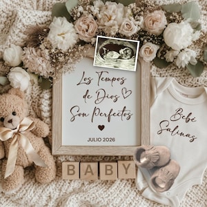 May include: A baby announcement scene with a teddy bear, floral arrangement, and ultrasound image. A framed sign reads "Los Tiempos de Dios Son Perfectos" and "Julio 2026." A onesie says "Bebé Salinas" with baby shoes and wooden blocks spelling "BABY."