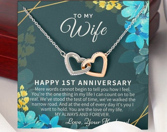 May include: A silver necklace with two interlocking hearts, one silver and one rose gold, in a gift box with a card that reads "To My Wife Happy 1st Anniversary". Mere words cannot begin to tell you how I feel. You're the one thing in my life I can count on to be real. We've stood the test of time, we've walked the narrow road. And at the end of every day it's you I want to hold. You are the love of my life. My Always and Forever. Love, Your Husband"