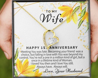 May include: A gold heart necklace with a clear crystal in the center, presented in a box with a floral design and a message that reads "To My Wife Happy 1st Anniversary Meeting You was fate. Becoming your friend was a choice, but falling in love with You was beyond my control. You're not a one in a million kind of girl, but a once in a lifetime kind of Woman. I loved You then and I love You still. Always have. Always will. Love, Your Husband"