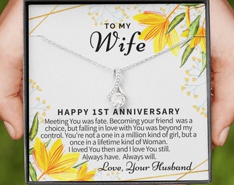 May include: A white gift box with a floral design and the words "To My Wife" and "Happy 1st Anniversary". The box contains a silver necklace with a clear crystal pendant. The text inside the box reads "Meeting You was fate. Becoming your friend was a choice, but falling in love with You was beyond my control. You're not a one in a million kind of girl, but a once in a lifetime kind of Woman. I loved You then and I love You still. Always have. Always will. Love, Your Husband."