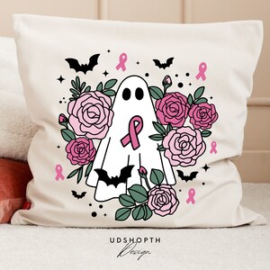 May include: A white pillow with a pink and black design featuring a ghost with a pink ribbon, bats, and roses. The text "UDSHOPTH Design" is at the bottom of the pillow.