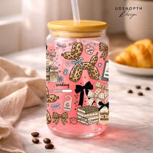 May include: A white ceramic mug with a black handle and the text "But First, Coffee" in a black, handwritten-style font. The mug is on a white surface.