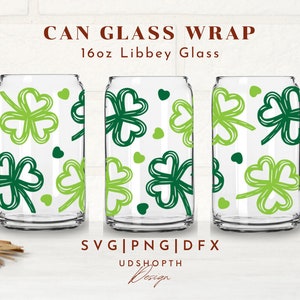 May include: Three 16oz Libbey glass can wraps with a green shamrock pattern. The text "CAN GLASS WRAP" and "16oz Libbey Glass" is at the top of the image. The text "SVG|PNG|DFX" and "UDSHOPTH Design" is at the bottom of the image.